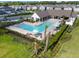 Aerial view showcases a fenced community pool area, complete with seating and lush landscaping at 4177 Beeswax Ln, Land O Lakes, FL 34638