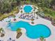 Aerial view of a community pool featuring seating, palm trees, and lush landscaping at 4177 Beeswax Ln, Land O Lakes, FL 34638