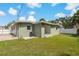 A view of the grassy backyard that features a sliding glass door, small patio, and modern exterior at 433 Pineapple St, Tarpon Springs, FL 34689