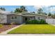 Charming single-story home featuring a well-manicured lawn and lush landscaping at 433 Pineapple St, Tarpon Springs, FL 34689