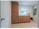 Bright laundry room featuring wood cabinets, a white countertop, and stainless steel faucet under a window at 433 Pineapple St, Tarpon Springs, FL 34689