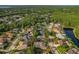Aerial view of a neighborhood boasting lush green trees, tranquil streets, and a nearby lake at 4530 Roanoak Way, Palm Harbor, FL 34685
