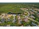 Aerial view showcasing a lush community, mature trees, and a tranquil lake, creating a peaceful neighborhood at 4530 Roanoak Way, Palm Harbor, FL 34685