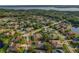 Aerial neighborhood view showcasing mature trees, peaceful streets, and manicured lawns, near a lake at 4530 Roanoak Way, Palm Harbor, FL 34685