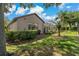 Well-maintained backyard with green lawn, mature trees, and screened-in lanai, perfect for outdoor relaxation at 4530 Roanoak Way, Palm Harbor, FL 34685