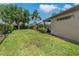 A large grassy backyard has partial fencing and exterior view of lanai at 4530 Roanoak Way, Palm Harbor, FL 34685