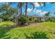 A large backyard is fully fenced in with lush, green grass and mature landscaping at 4530 Roanoak Way, Palm Harbor, FL 34685