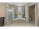 Spa-like bathroom with a soaking tub, glass-enclosed shower, and a window for natural light at 4530 Roanoak Way, Palm Harbor, FL 34685