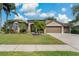 Charming single-story home with a well-manicured lawn, mature landscaping, and an attached garage at 4530 Roanoak Way, Palm Harbor, FL 34685