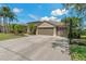 Beautiful home with a long driveway leading to a three-car garage and a basketball hoop at 4530 Roanoak Way, Palm Harbor, FL 34685