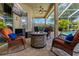 Covered lanai with comfortable seating, a fire pit, and views of the pool and backyard at 4530 Roanoak Way, Palm Harbor, FL 34685