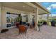Inviting covered patio featuring brick pavers, comfortable seating, TV, and ceiling fan for outdoor entertainment at 4530 Roanoak Way, Palm Harbor, FL 34685