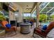 Relaxing screened-in patio with comfortable seating area, gas fire pit, ceiling fan, and a view of the pool at 4530 Roanoak Way, Palm Harbor, FL 34685