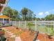 Fenced backyard featuring a well maintained garden space with beautiful trees and a scenic lake view at 4813 Glenaire Ct, Tampa, FL 33624
