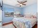 Cozy bedroom with wood floors, ceiling fan, and window offering natural light and view of the outdoors at 4813 Glenaire Ct, Tampa, FL 33624