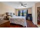 Bright bedroom with wood floors, a ceiling fan, and a large window offering a view of a pond at 4813 Glenaire Ct, Tampa, FL 33624