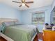 Bright bedroom with a ceiling fan, wood floors, and a window offering natural light and outdoor views at 4813 Glenaire Ct, Tampa, FL 33624