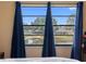 Bedroom view with blue curtains overlooking a serene lake and neighborhood at 4813 Glenaire Ct, Tampa, FL 33624
