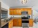 Bright kitchen featuring wood cabinets, granite countertops, and modern appliances for a functional cooking space at 4813 Glenaire Ct, Tampa, FL 33624