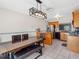 Bright kitchen boasts stainless steel appliances, wood cabinets, and modern lighting fixture over a large wooden table at 4813 Glenaire Ct, Tampa, FL 33624