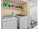 Laundry area with white washer and dryer, shelving, and a toilet at 4813 Glenaire Ct, Tampa, FL 33624