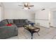 Bright living room with a large sectional sofa, neutral walls, tile flooring and a modern ceiling fan at 4813 Glenaire Ct, Tampa, FL 33624