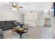 Open living room with a large sectional, tile floors, access to stairs, and space for entertaining at 4813 Glenaire Ct, Tampa, FL 33624