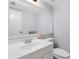 Powder room featuring white sink, toilet, and large mirror in a well-lit space at 4813 Glenaire Ct, Tampa, FL 33624