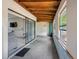 Enclosed sunroom featuring concrete flooring, wood-paneled ceiling and natural light from a large window and sliding glass door at 4813 Glenaire Ct, Tampa, FL 33624
