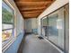 Enclosed sunroom featuring concrete flooring, wood-paneled ceiling and natural light from a large window and sliding glass door at 4813 Glenaire Ct, Tampa, FL 33624