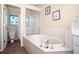 Bright bathroom features a large soaking tub, glass shower, and stained glass window at 5205 Fairway One Dr, Valrico, FL 33596