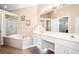 Bathroom with a soaking tub, dual vanities, and tiled floors at 5205 Fairway One Dr, Valrico, FL 33596