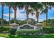 Fairway One entrance sign with stone accents and palm trees, set against a blue sky backdrop at 5205 Fairway One Dr, Valrico, FL 33596