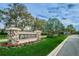 Stone sign for River Hills Golf and Country Club, featuring manicured landscaping and a palm tree at 5205 Fairway One Dr, Valrico, FL 33596