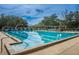 Large community swimming pool with lap lanes, shaded seating, and mature landscaping at 5205 Fairway One Dr, Valrico, FL 33596