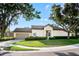 Beautiful home showcasing a two-car garage, lush green lawn, and carefully trimmed hedges at 5205 Fairway One Dr, Valrico, FL 33596