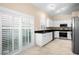 Bright kitchen with white cabinets, stainless steel appliances, and a sliding glass door for natural light at 5205 Fairway One Dr, Valrico, FL 33596