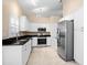 Bright kitchen featuring white cabinets, black granite countertops, and stainless steel appliances at 5205 Fairway One Dr, Valrico, FL 33596