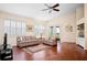 Bright living room with plantation shutters, hardwood floors, and a ceiling fan at 5205 Fairway One Dr, Valrico, FL 33596