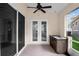 A covered patio features an outdoor kitchen area with built-in cabinets, sink, and a ceiling fan at 5205 Fairway One Dr, Valrico, FL 33596