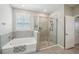 Modern bathroom featuring a soaking tub and glass-enclosed shower at 5411 Thistle Field Ct, Wesley Chapel, FL 33545