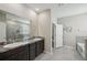This bathroom features double sinks with granite countertops, a glass shower, and a soaking tub at 5411 Thistle Field Ct, Wesley Chapel, FL 33545