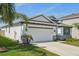 Beautiful single-story home with a well-manicured lawn, featuring a two-car garage with white door at 5411 Thistle Field Ct, Wesley Chapel, FL 33545