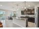 Modern kitchen with a center island, stainless steel appliances, dark wood cabinetry, and a view to the dining area at 5411 Thistle Field Ct, Wesley Chapel, FL 33545