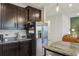 This kitchen features stainless steel appliances and dark cabinets, complete with granite countertops at 5411 Thistle Field Ct, Wesley Chapel, FL 33545