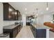Beautiful kitchen featuring granite countertops, dark cabinetry, stainless appliances, and a large center island at 5411 Thistle Field Ct, Wesley Chapel, FL 33545