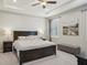 This main bedroom features a tray ceiling, a window with shutters, and neutral decor at 5411 Thistle Field Ct, Wesley Chapel, FL 33545
