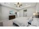 This main bedroom features a tray ceiling, a tv, and neutral decor at 5411 Thistle Field Ct, Wesley Chapel, FL 33545