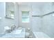 Updated bathroom with a marble vanity, updated fixtures, and a shower with white marble tile surround at 6004 S 82Nd St, Tampa, FL 33619