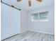 Bright bedroom boasts light wood flooring, a ceiling fan, and a closet with stylish sliding doors at 6004 S 82Nd St, Tampa, FL 33619